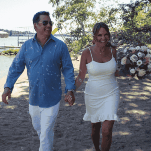 Erica Suzanne Matchmaking and her husband Tom on a beach wearing formal attire after getting married