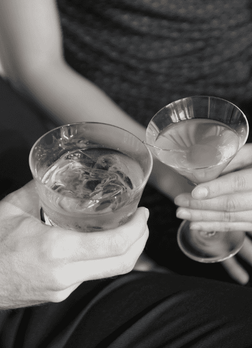 Black and white photo of a high class couple holding cocktails